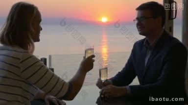 年轻男女度过浪漫夜晚的慢镜头他们在阳台上碰杯喝酒